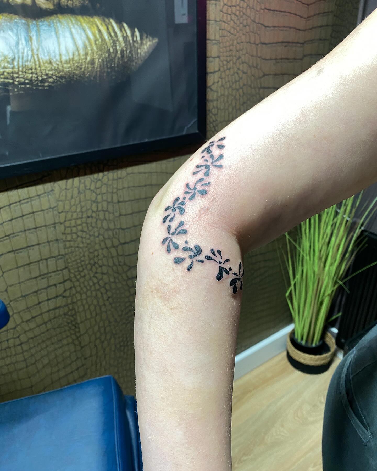 Floral wrap tattoo aan de binnenkant van een elleboog, in de studio